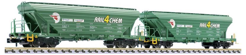 Zwei grüne AIL4CHEM-Güterwagen-Schüttgüterwaggons auf Gleisen, nebeneinander dargestellt mit Leitern und gelben Armaturen.
