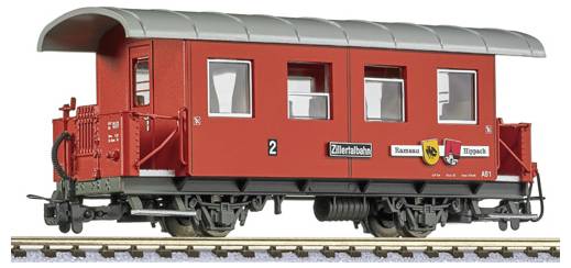Red model railway passenger caboose with black roof and red undercarriage, shown on tracks.