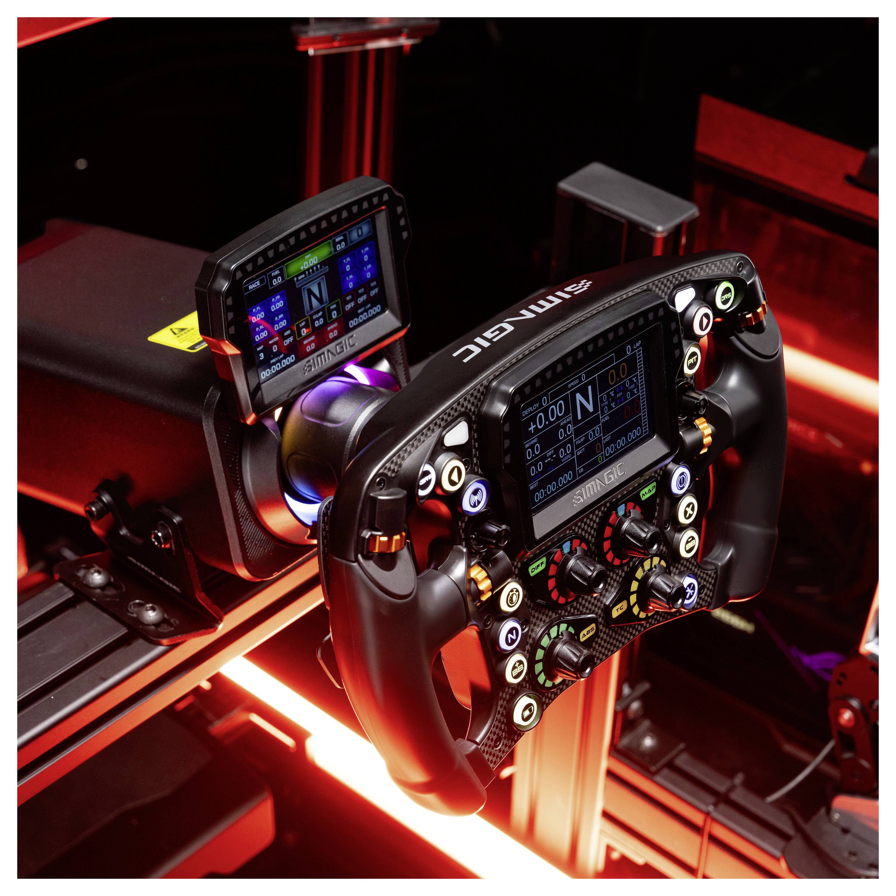 Nahaufnahme eines Rennsimulatoren-Lenkrads und einer Instrumententafel mit leuchtenden Schaltflächen und digitalen Anzeigefeldern in einem rot beleuchteten Cockpit.