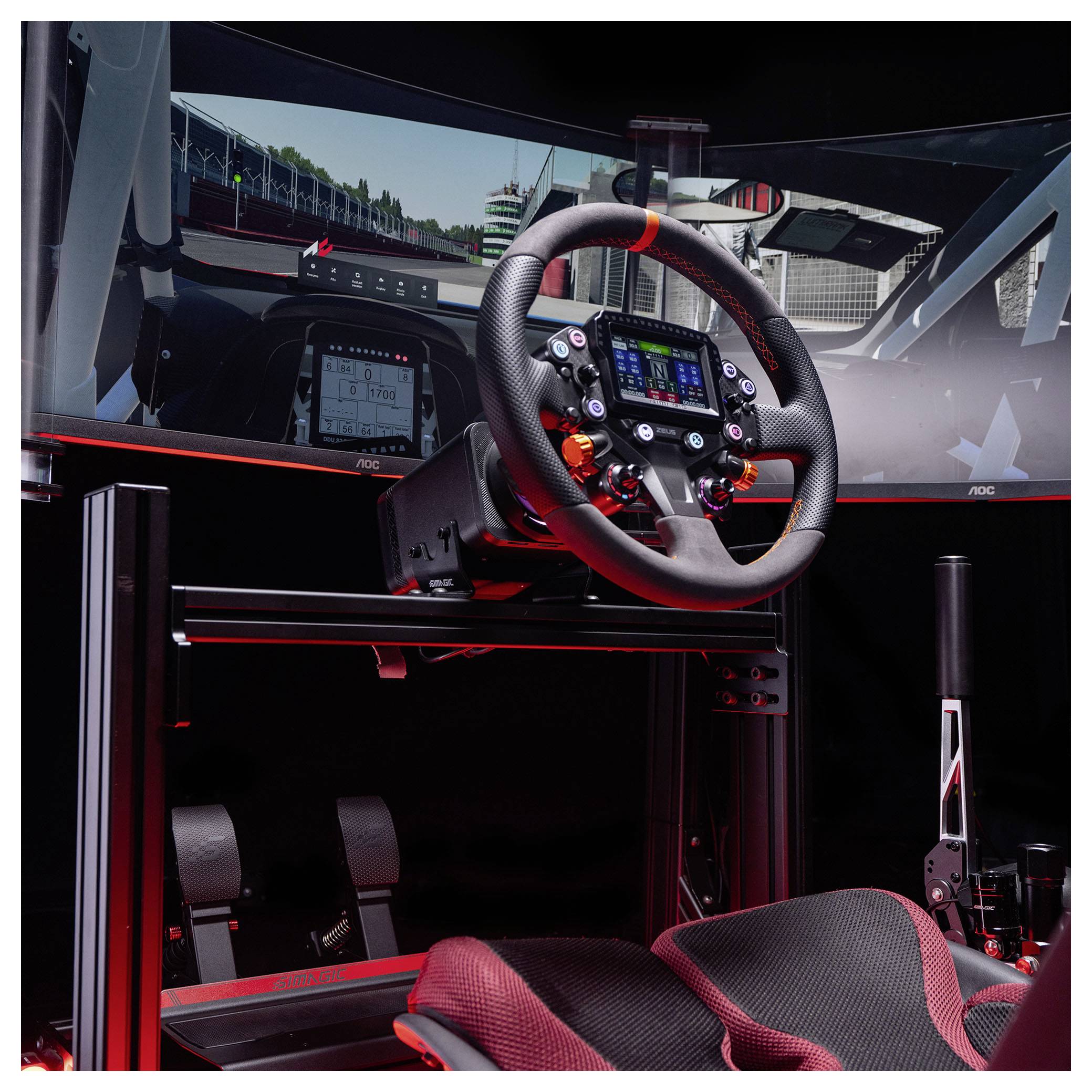Rennsimulatoren-Cockpit mit Lenkrad, Pedalen und zwei Monitoren, die eine Streckenansicht zeigen, rot beleuchtet.