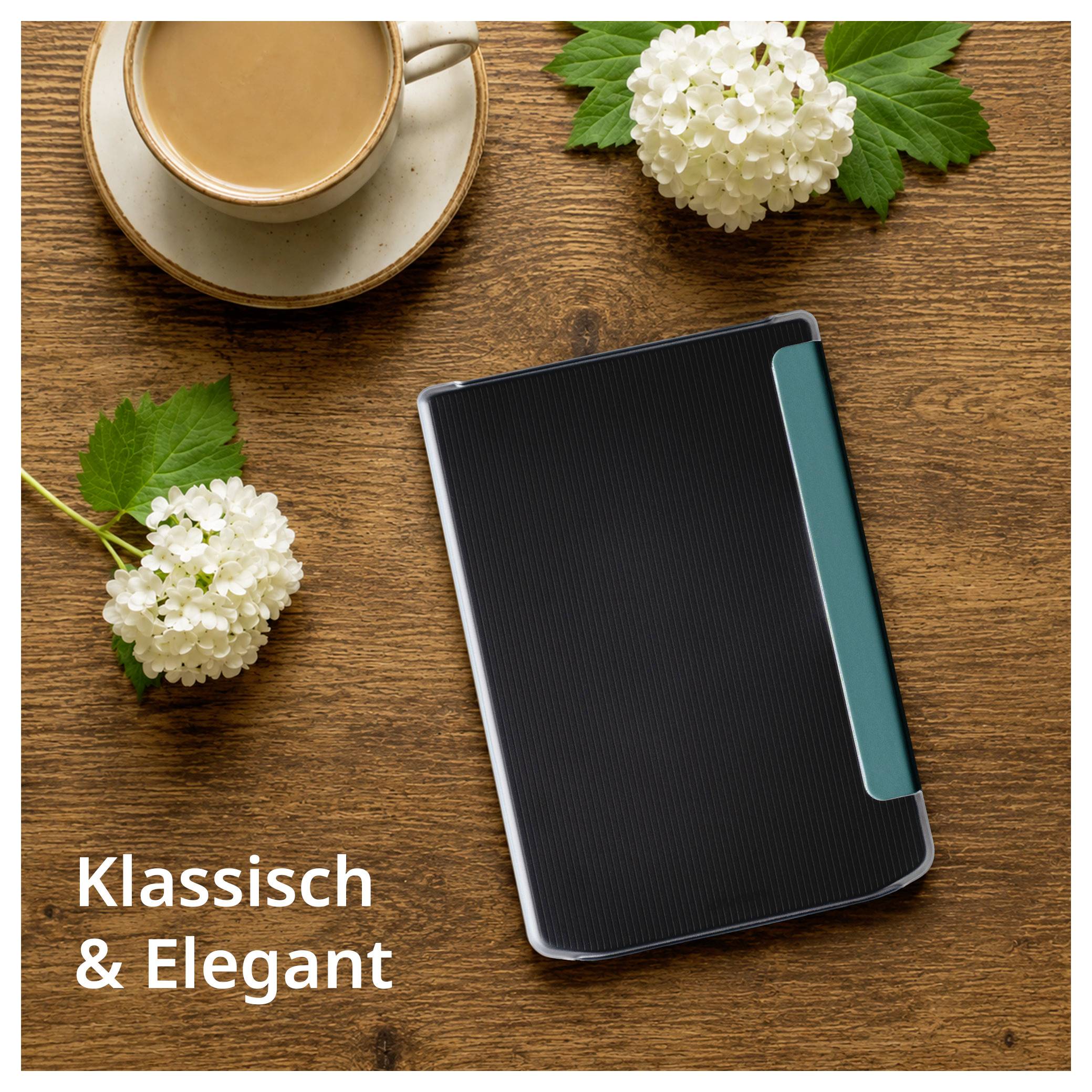 Schwarzes Notizbuch mit türkisfarbenem Lesezeichen auf einem Holztisch neben einer Kaffeetasse und weißen Blumen; Text sagt „Klassisch & Elegant