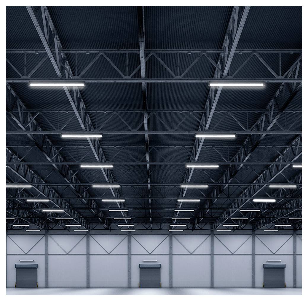 Leeres Industrielagerhaus-Interieur mit hoher Metallfachwerk-Decke, hellen Deckenleuchtstoffröhren und drei Ladebuchten an der Rückwand.