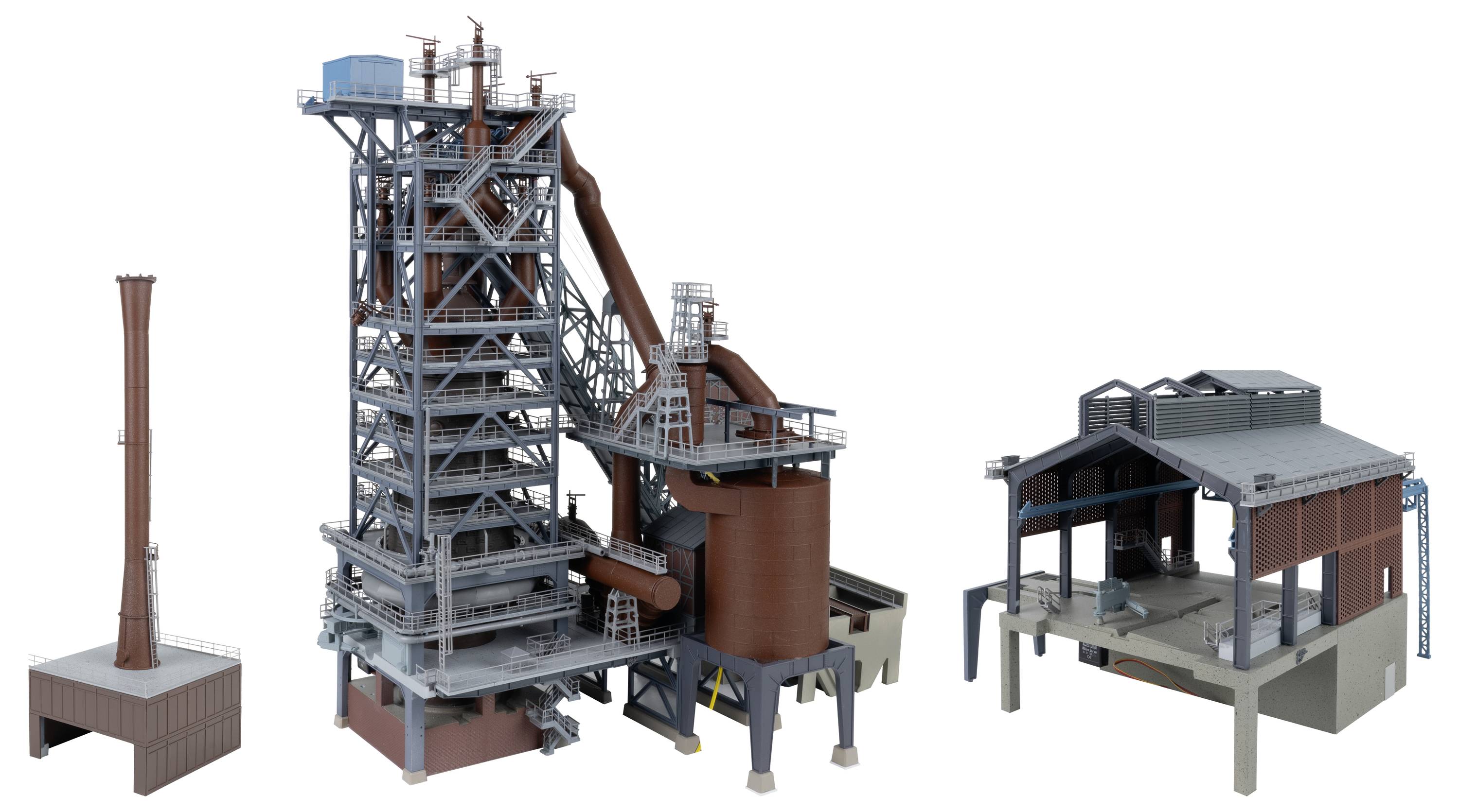 Drei industrielle 3D-Modelle: eine große Stahlverarbeitungsanlage mit Förderband und Silo, eine kleinere Schornsteinstruktur und ein offenseitiges Versorgungsgebäude.