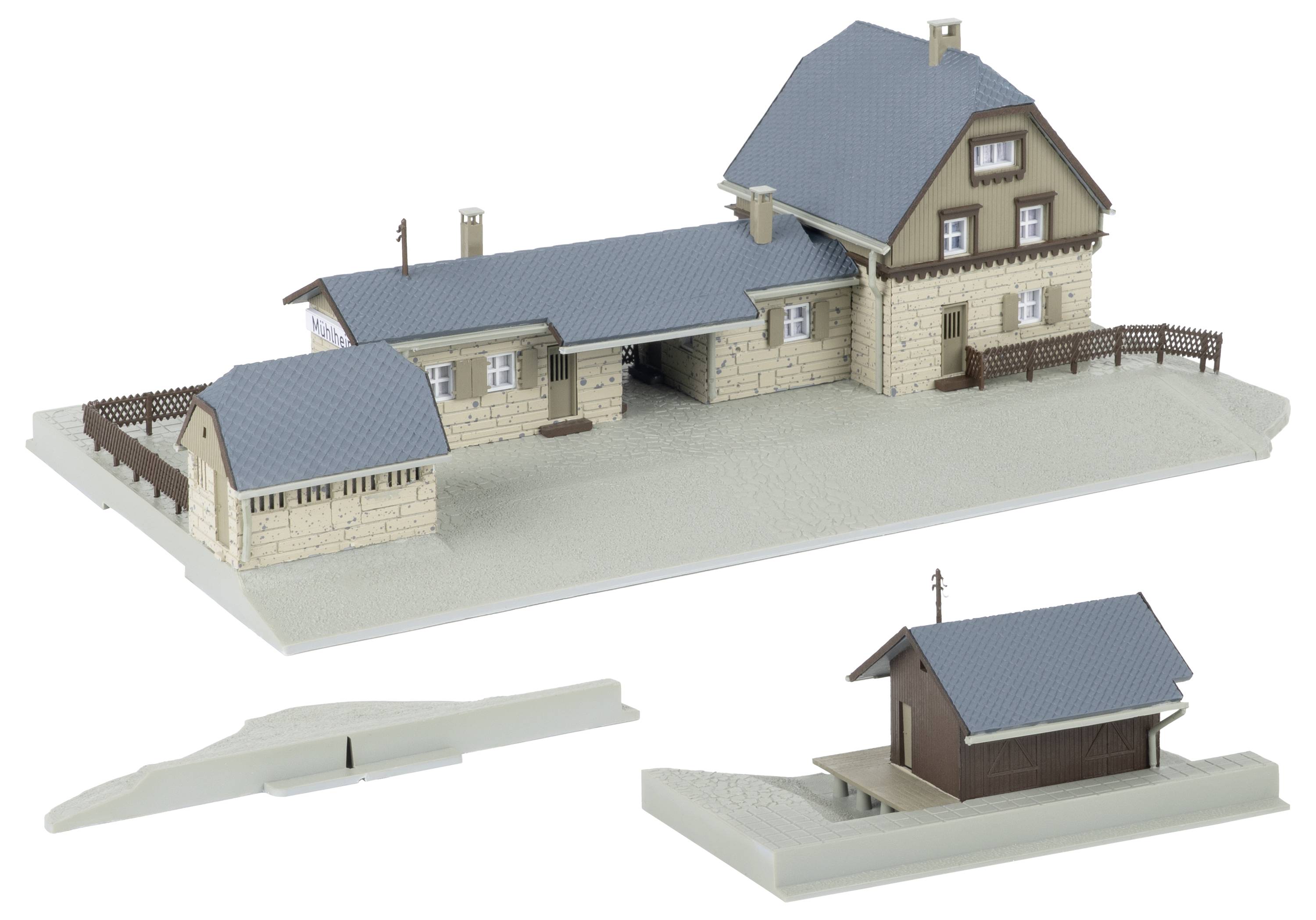 Architekturmodell eines beige Hauses mit blauem Dach auf grauer Basis, plus zwei unten gezeigt separate kleinere Gebäudeabschnitte.
