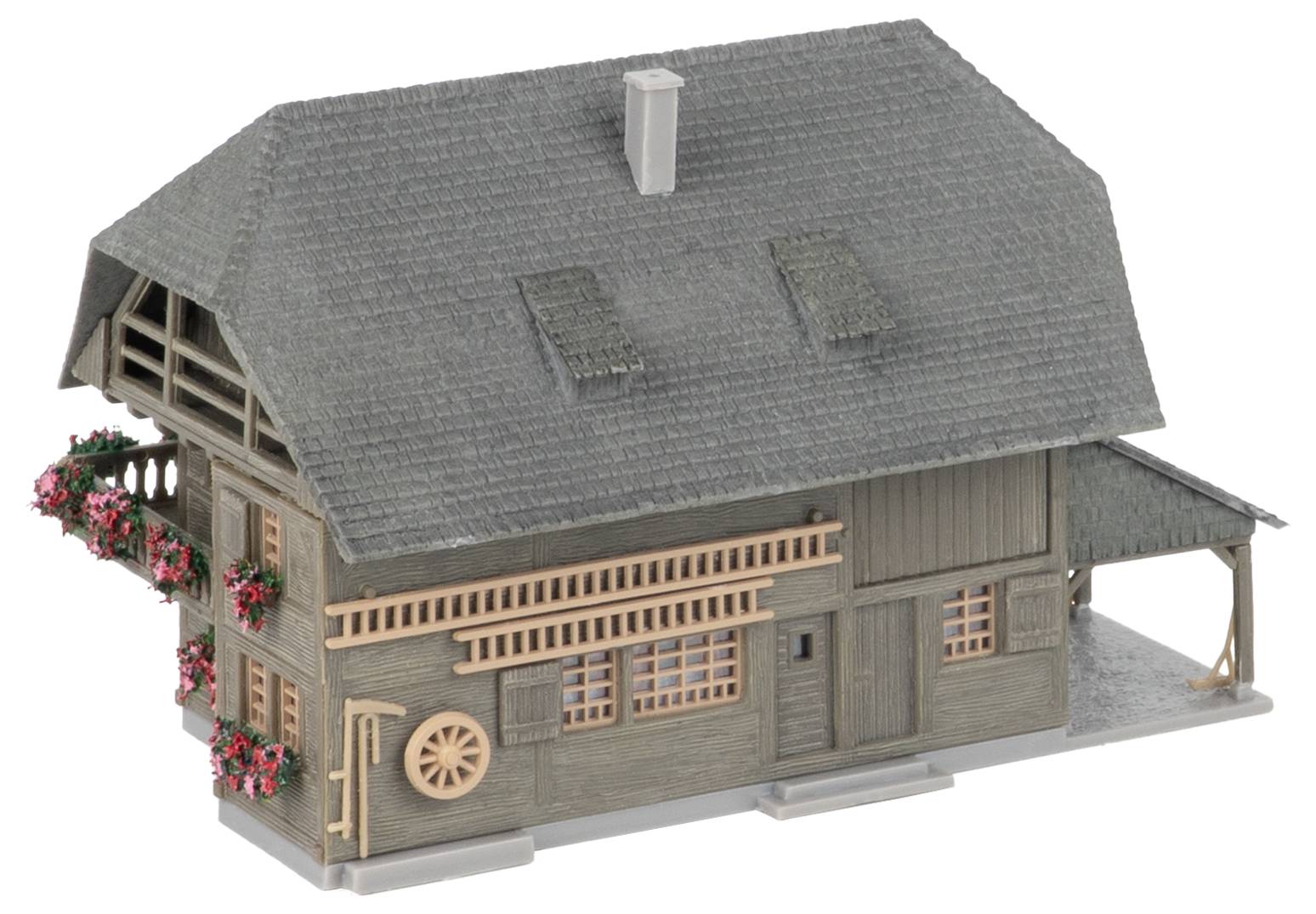 Modell eines rustikalen Holzhauses mit grauem Schindeldach, Dachgauben, Veranda und roten Blumenkästen, dargestellt auf weißem Hintergrund.