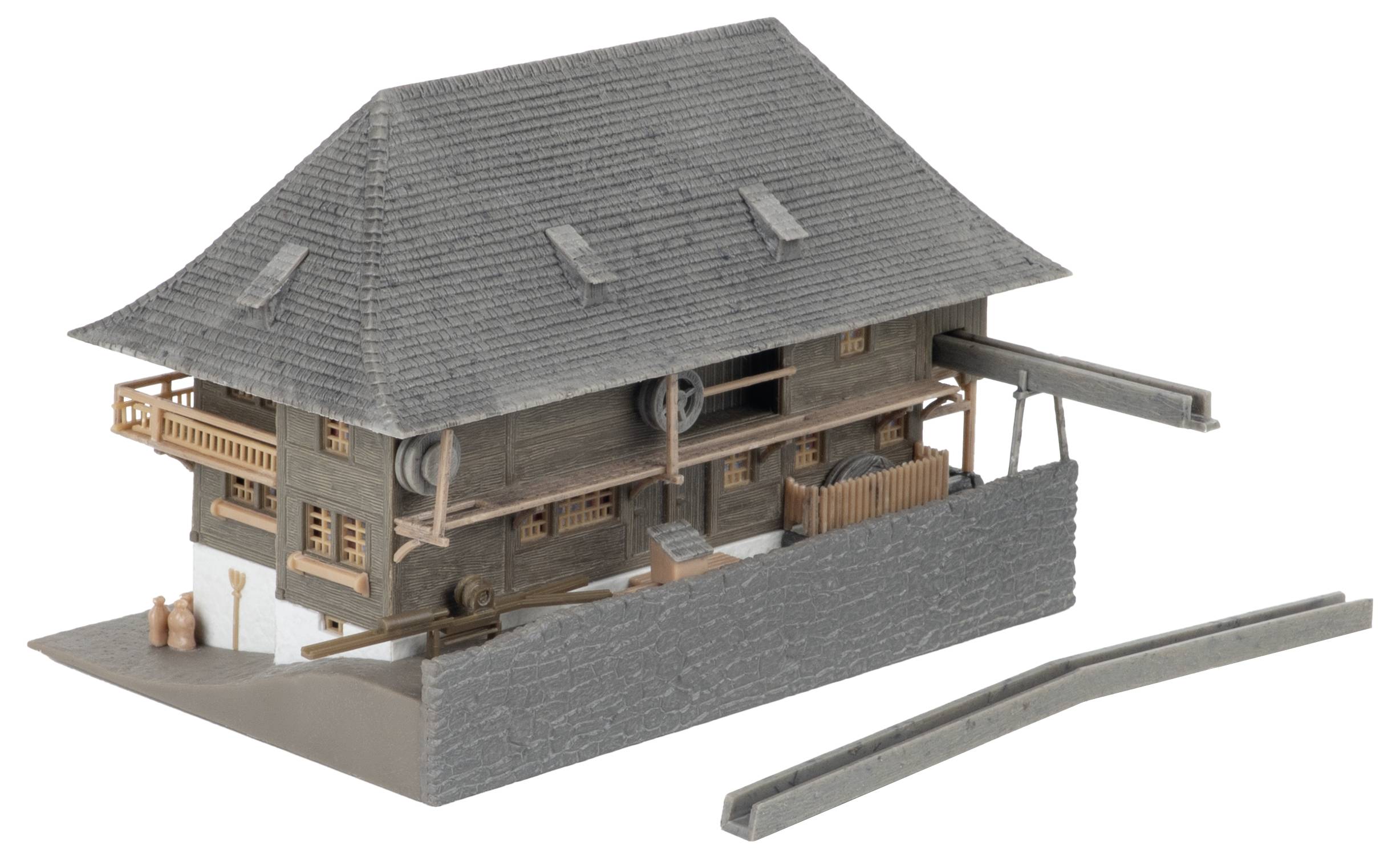 Modell eines rustikalen Holzhauses mit steilem grauem Dach, dargestellt auf einem Sockel mit niedriger Mauer und separatem Zaunteil.
