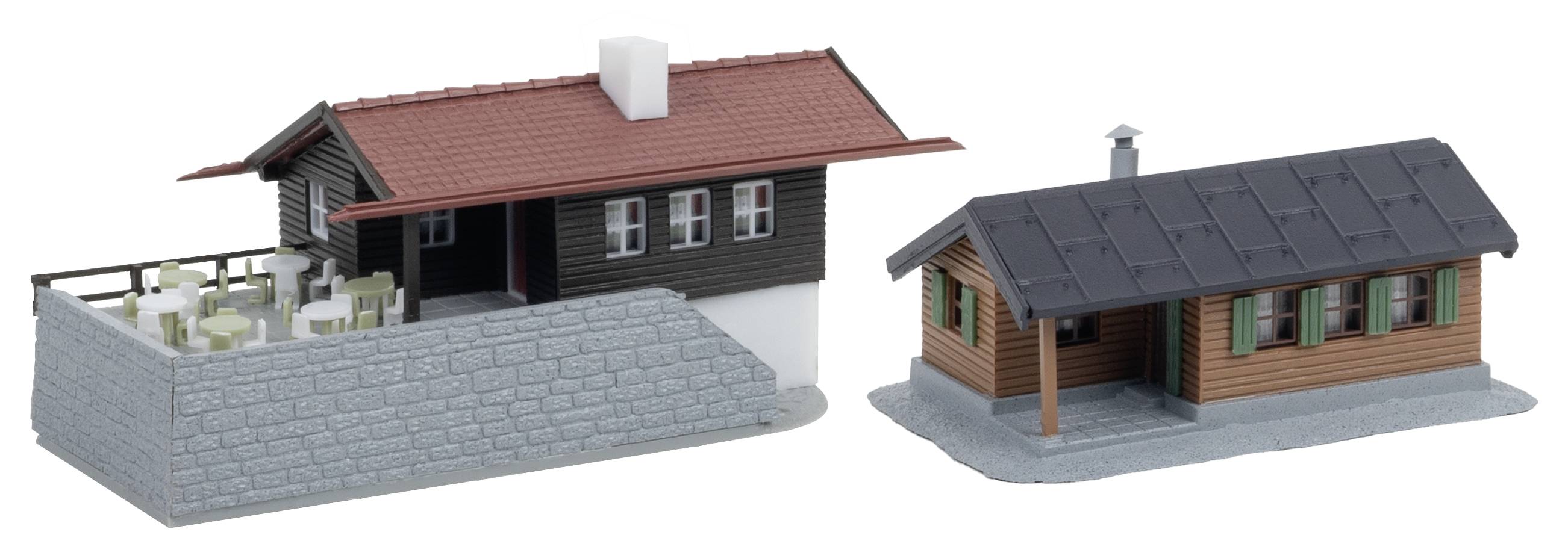 Zwei 3D-Hausmodelle: ein größeres schwarz-rotes Haus mit einer eingezäunten Steinterrasse und eine kleinere Holzhütte daneben.