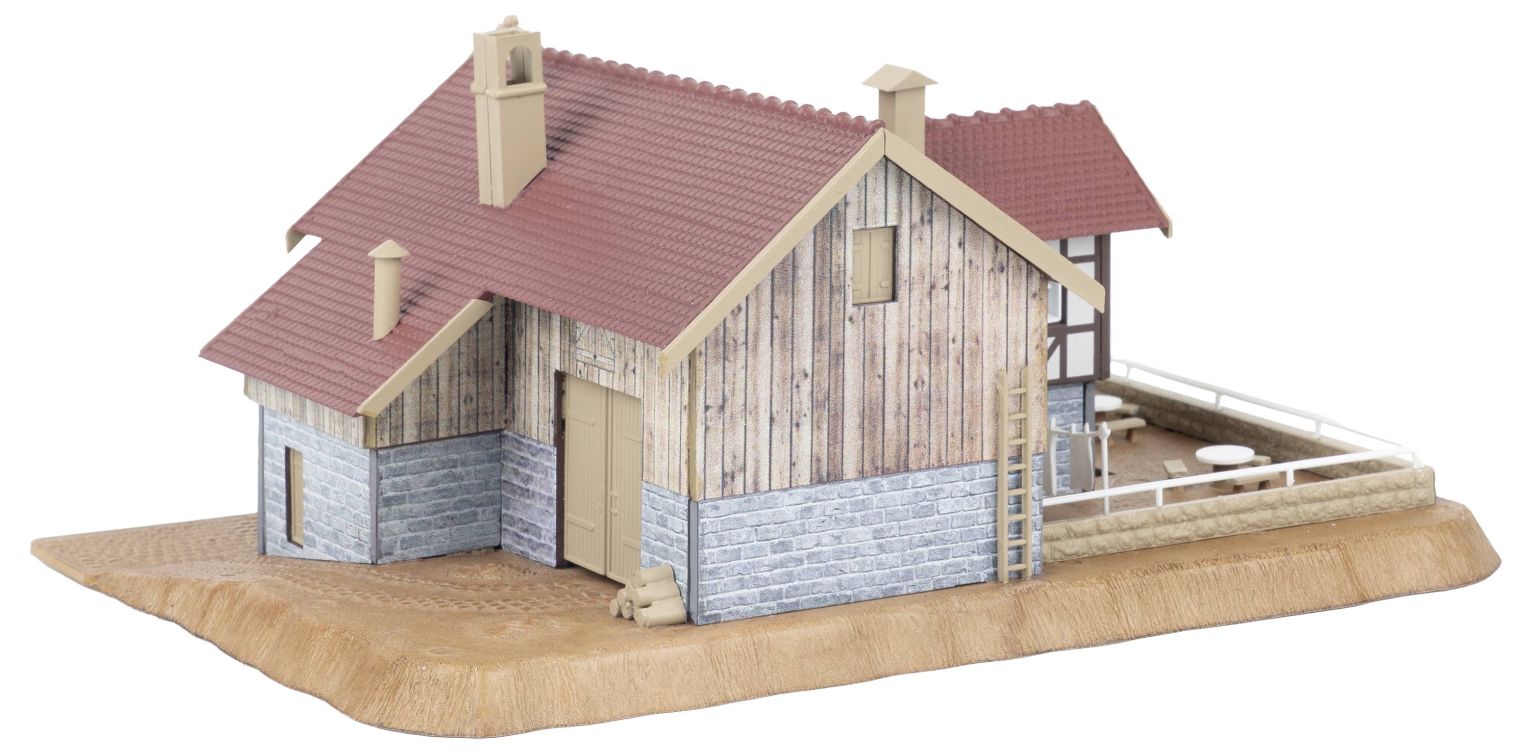 3D-Modell eines kleinen rustikalen Hauses mit rotem Dach, Holzverkleidung, Steinsockel und einer umzäunten Seitenterrasse auf einer Grundplattform