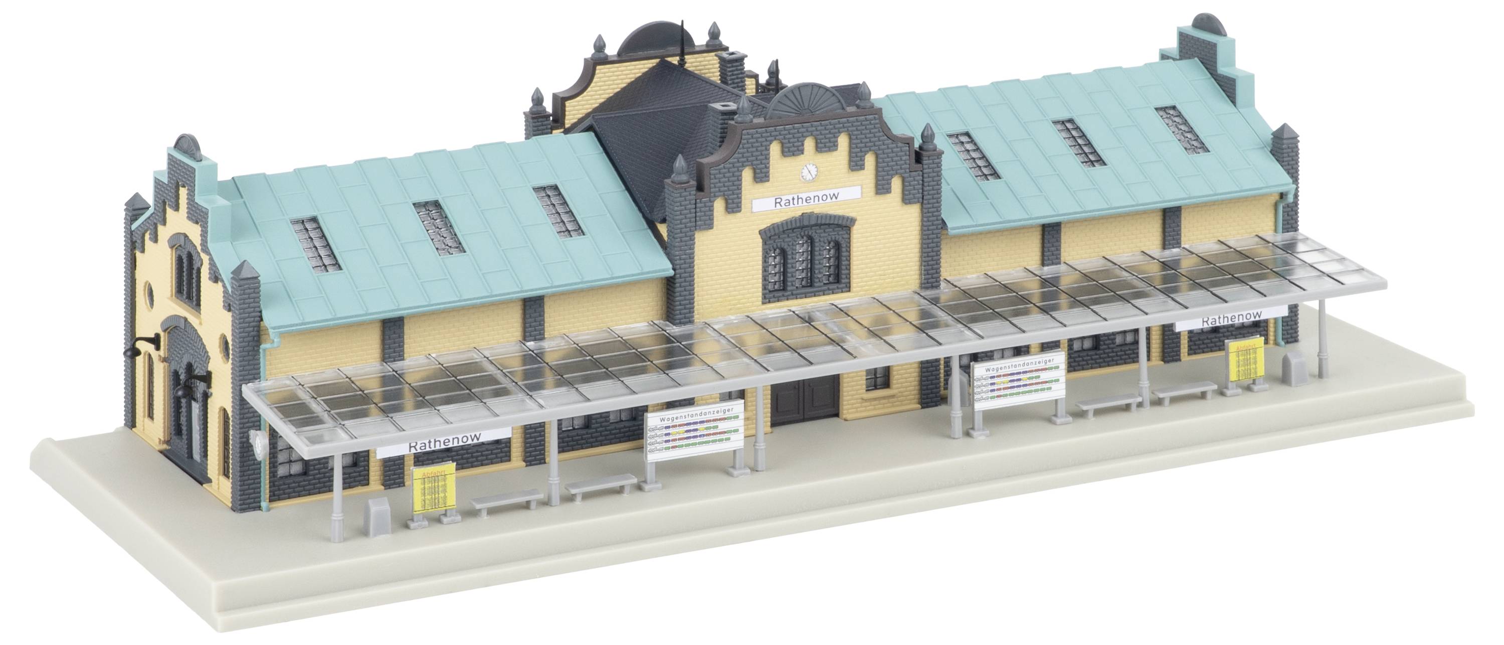 Architekturmodell einer creme- und blaugrünen Bahnstation mit einem überdachten Bahnsteigdach auf einer Ausstellungsbasis.