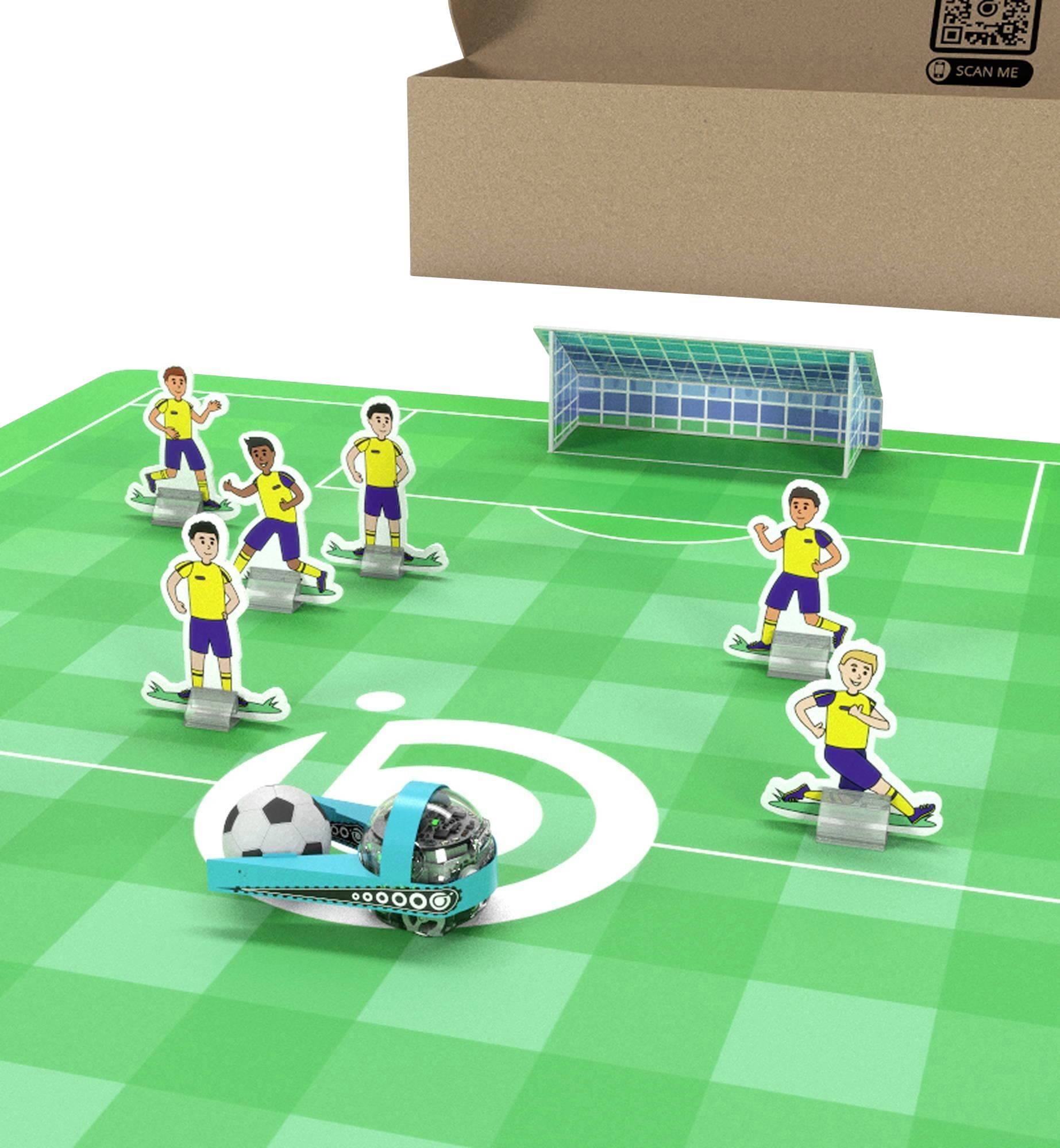 Spielzeuger-Fußballszene mit fünf Spieler-Ausschnitten, einem kleinen Tor und einem blauen Roboter auf einem grünen Feld neben einer Pappschachtel mit der Aufschrift „SCAN ME