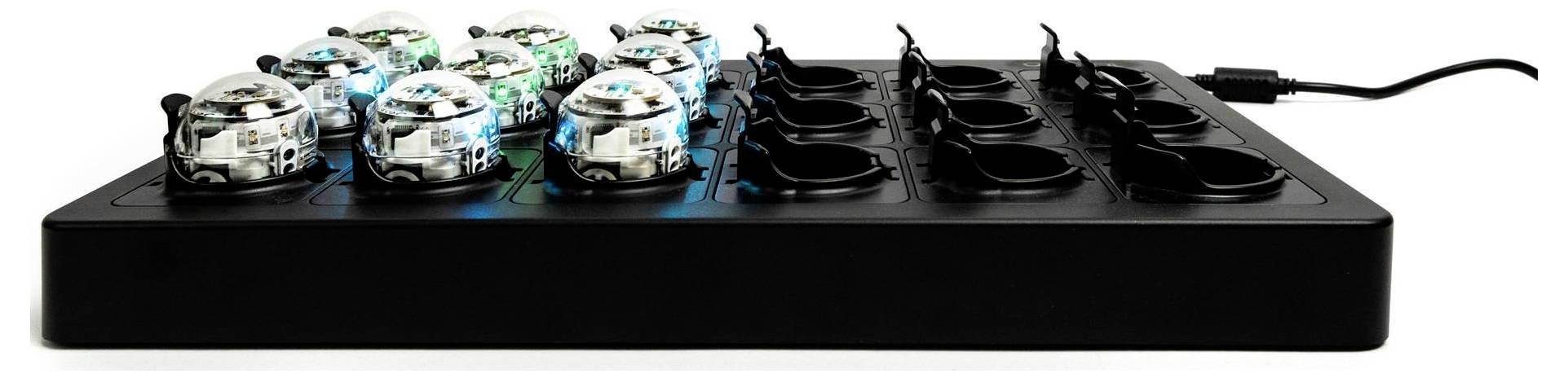 Schwarze rechteckige elektronische Steuereinheit mit sechs transparenten Kuppelleuchten, die blau leuchten, und sechs leeren schwarzen Steckplätzen auf der Oberseite, vor einem weißen Hintergrund gezeigt.