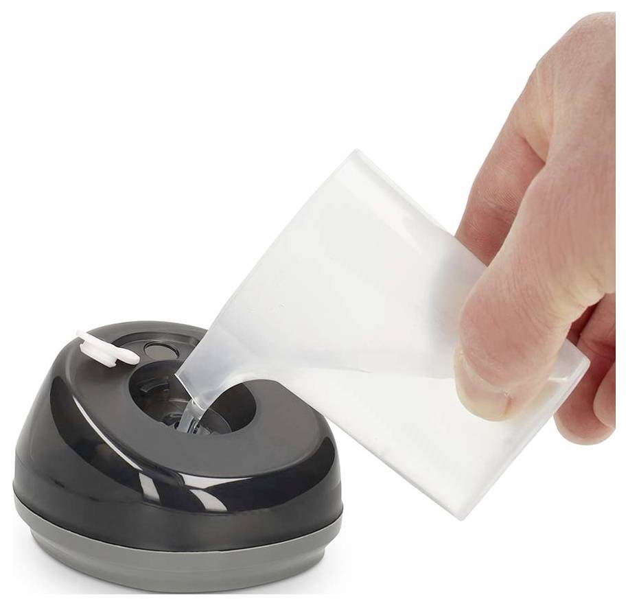 Eine Hand gießt Flüssigkeit aus einem kleinen durchsichtigen Behälter in einen schwarzen Tischdispenser oder Luftbefeuchter auf weißem Hintergrund.