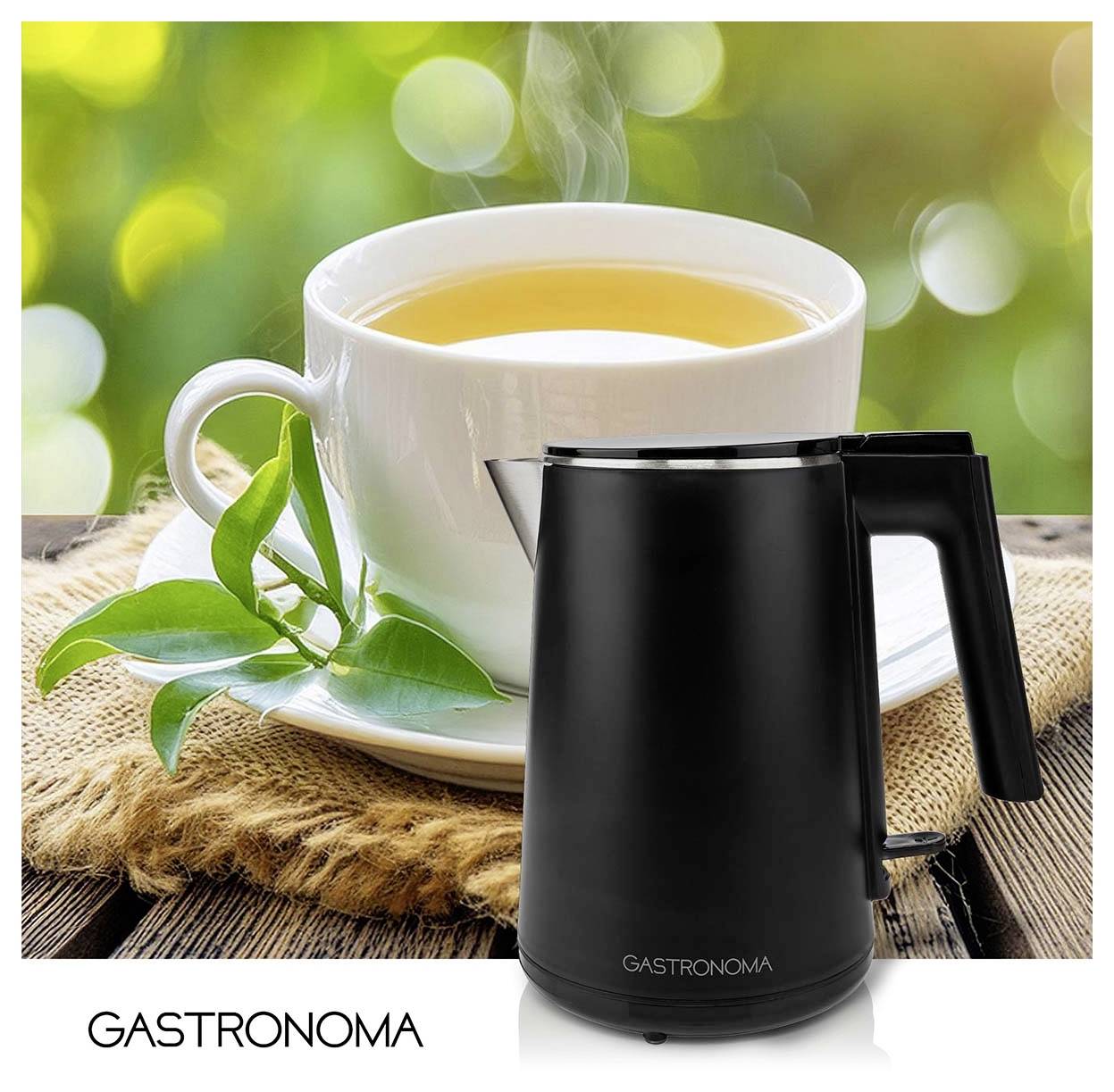 Schwarzer Gastronoma Wasserkocher vor einer weißen Teetasse und Untertasse mit Tee, was auf die Zubereitung von Tee oder heißem Wasser hindeutet.