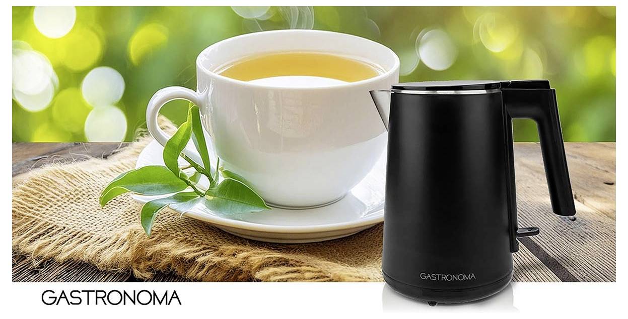 Werbebild einer weißen Teetasse auf einer Untertasse mit grünen Blättern neben einem schwarzen Gastronomia-Elektrokessel auf einem rustikalen Tisch.