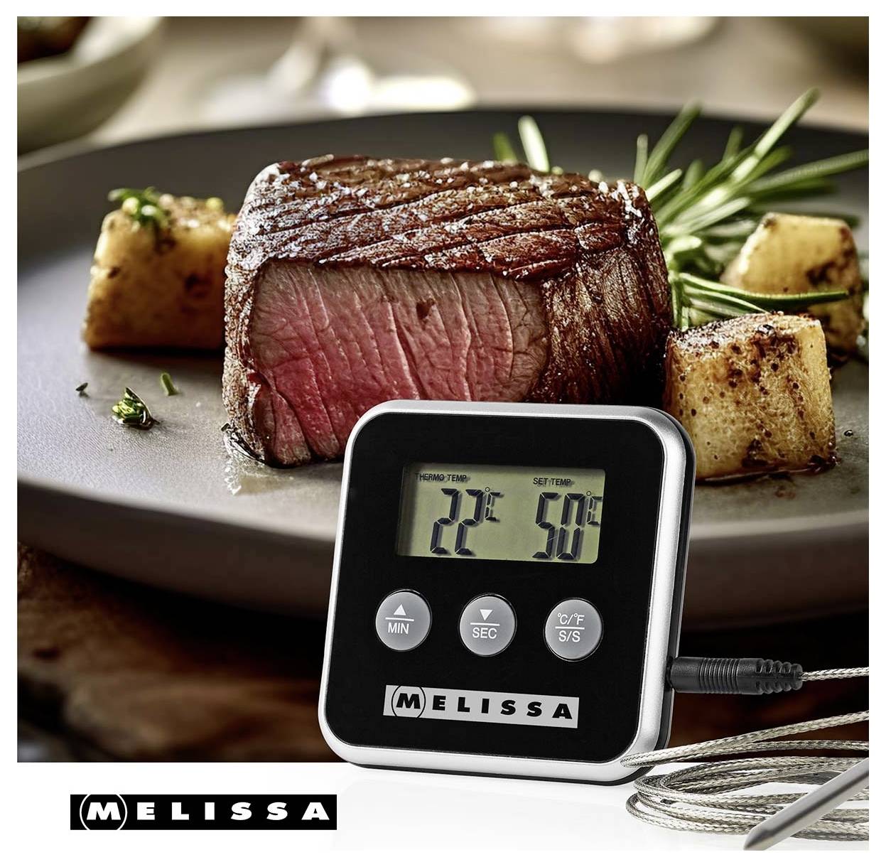 Digitales Küchen-Fleischthermometer zeigt 22°C und 50°C vor einem gekochten Rindersteak mit Kartoffeln und Rosmarin auf einem Teller.