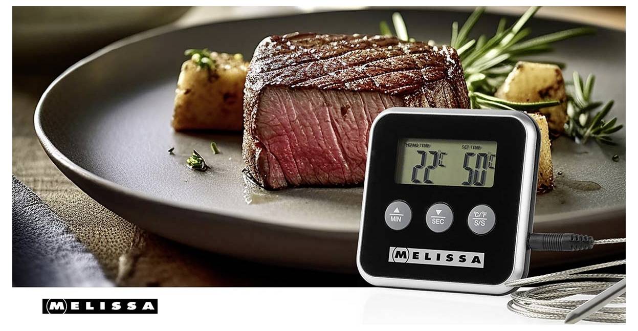Digitales Fleischthermometer zeigt 22°C und 50°C neben einem gebratenen Rindersteak auf einem Teller, mit dem 