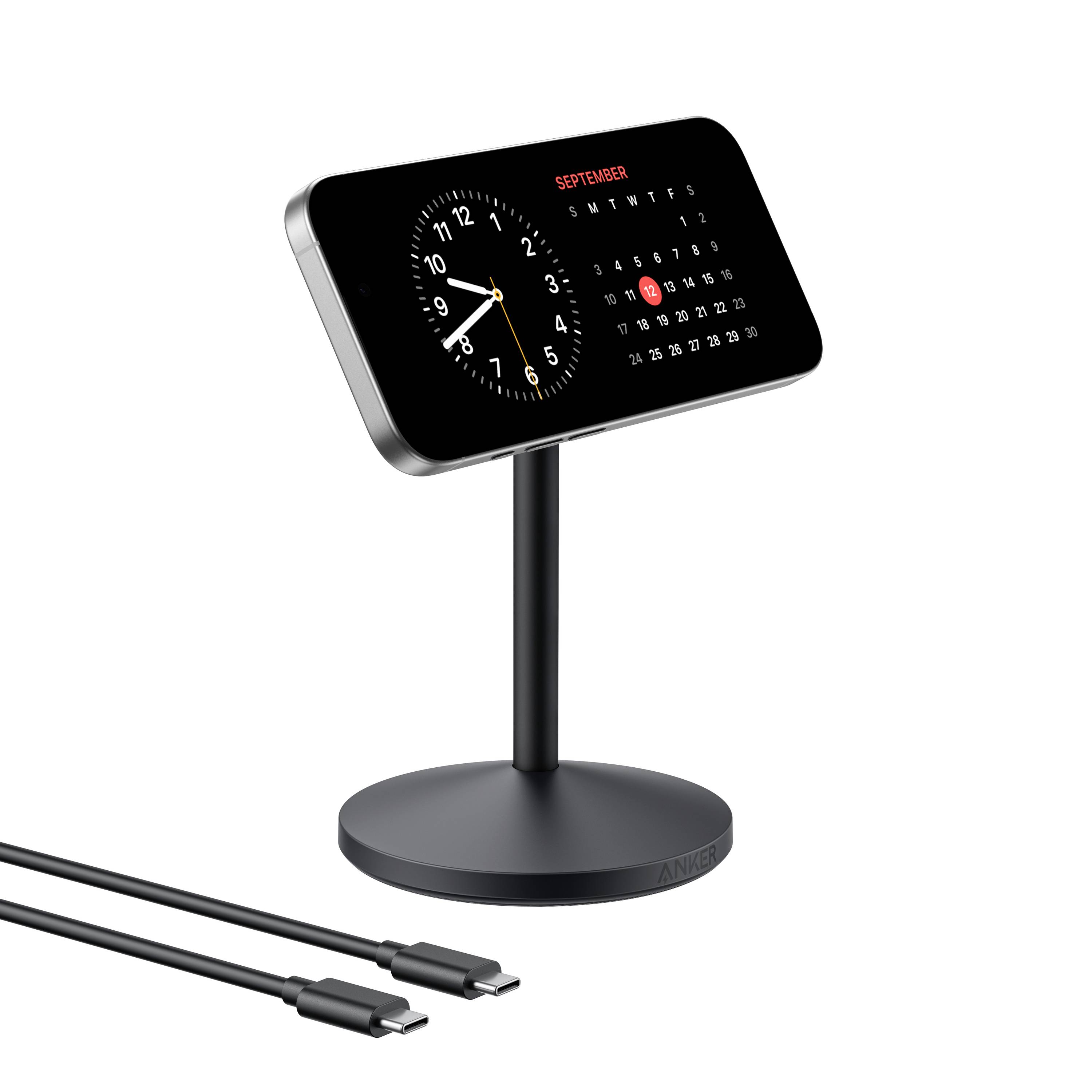 Digitale schwarze Uhr und Kalenderanzeige auf einem Ständer, mit zwei USB-C-Ladekabeln darunter abgebildet.