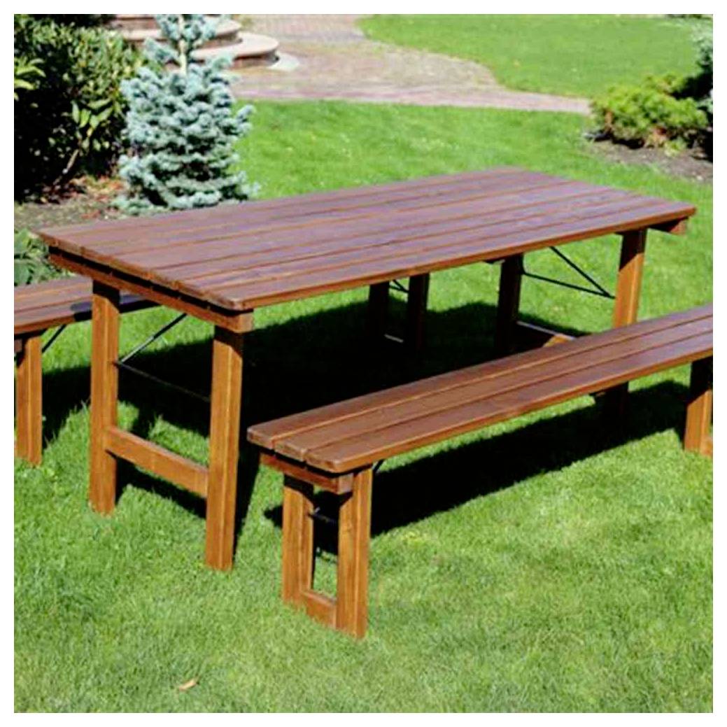 Holztisch für Außenpicknicks mit angebrachten Bänken auf einem Rasenplatz in einem Garten.