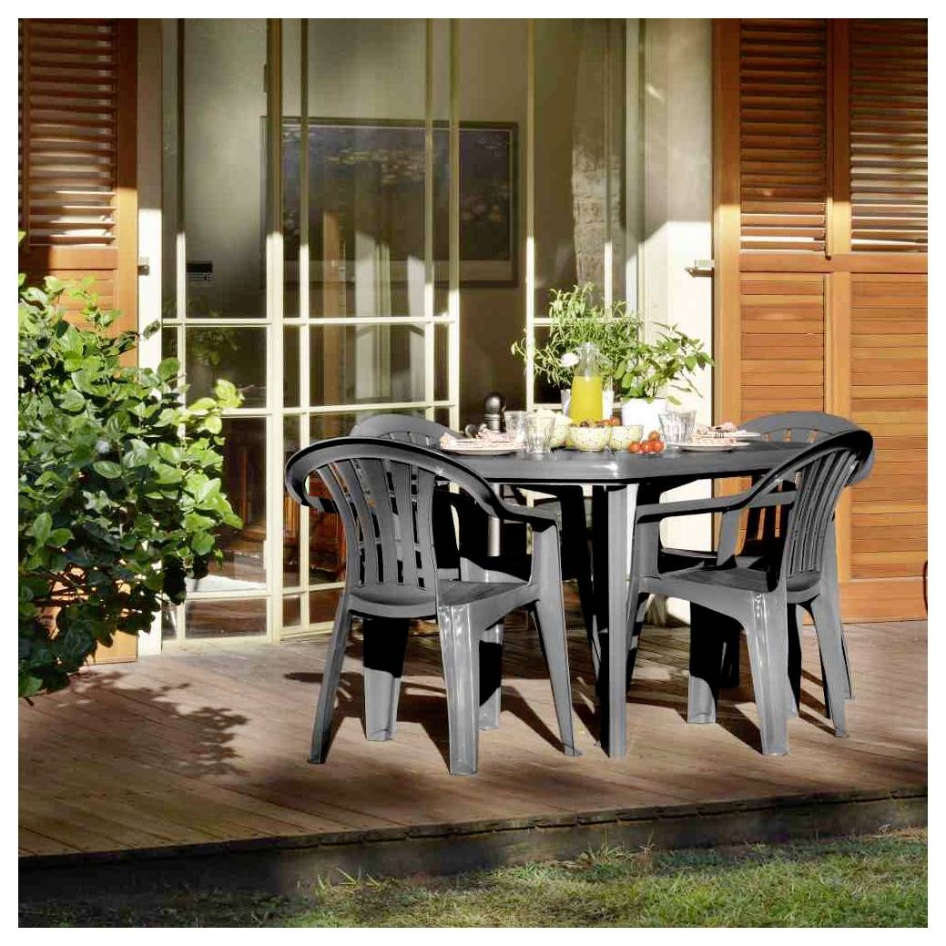 Outdoor-Patio mit schwarzem Kunststofftisch und vier Stühlen, gedeckt zum Essen, neben einer Glasschiebetür und Holzläden.