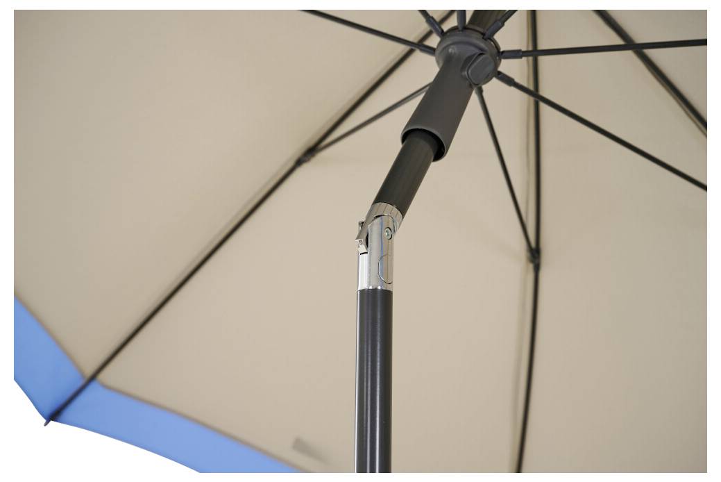 Nahaufnahme der Unterseite eines beigefarbenen Terrassenschirms mit schwarzem Mast und blauem Randsaum.