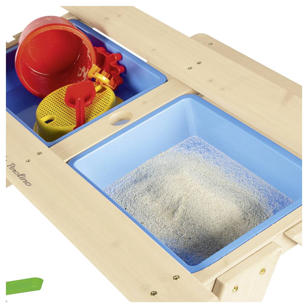 Holztisch mit Sinneserfahrungselementen mit blauen Behältern, die Sand enthalten, sowie farbigen Kunststoffschaufeln, Eimern und Zahnrädern.