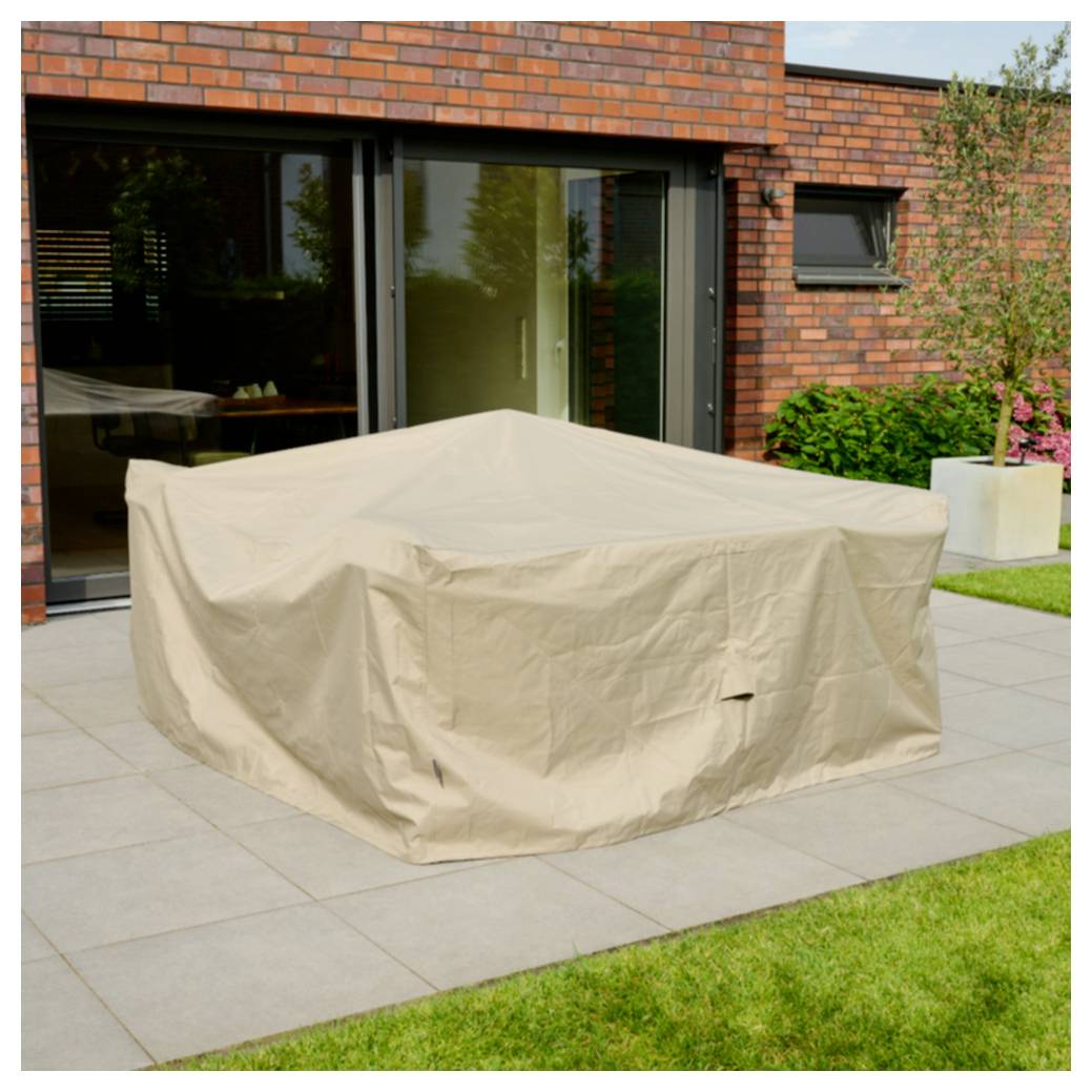 Beige-farbener Stoff bedeckt einen großen Außentisch oder eine Möbelgarnitur auf einer Terrasse außerhalb eines modernen Backsteinhauses.