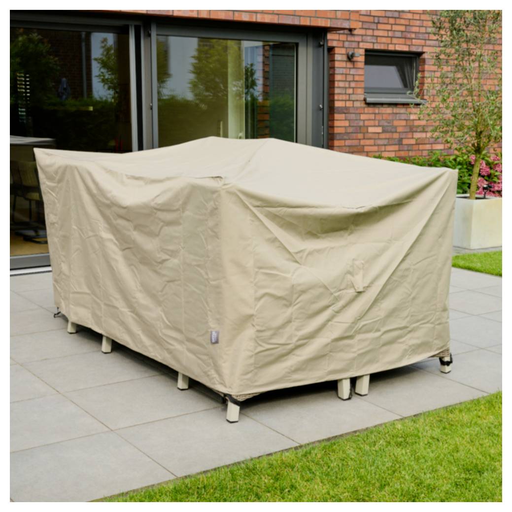 Eine beige Schutzhülle umhüllt Außenmöbel auf einer gefliesten Terrasse neben einem modernen Backsteinhaus und einem Rasen.