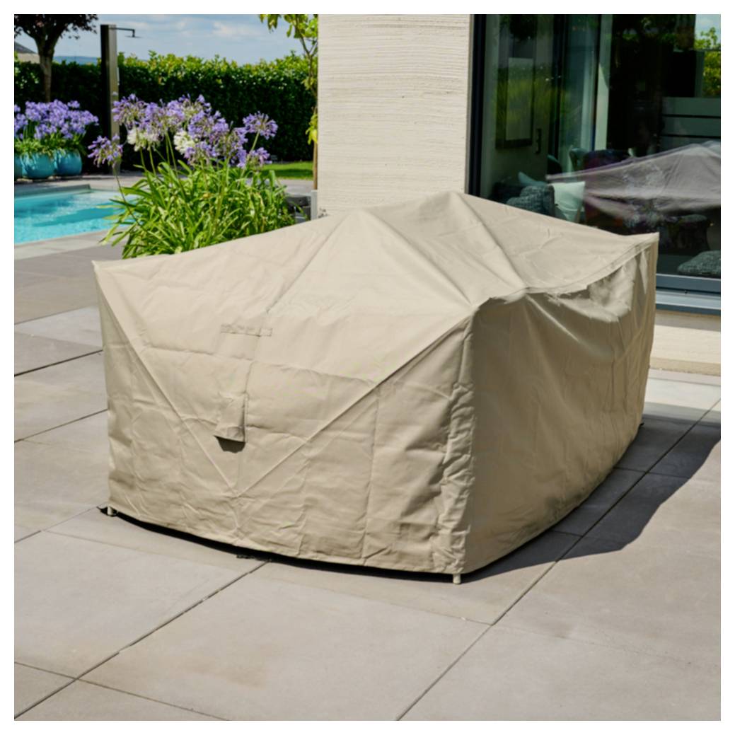 Beigefarbene Gartenmöbelabdeckung auf einer Terrasse neben einem Pool und Garten, die einen großen Stuhl oder ein Sofa schützt.