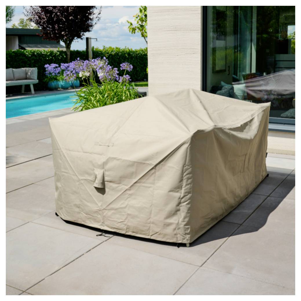 Überdachte Outdoor-Möbel neben einem Pool und Garten, mit einer beigen Schutzhülle auf einem Sofa oder Tisch.