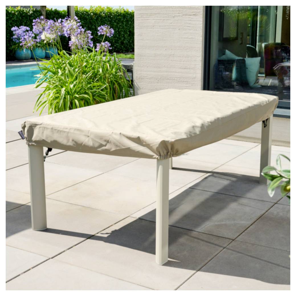 Beige rechteckiger Außentisch mit passendem Bezug auf einer sonnigen Terrasse neben einem Pool und Garten.