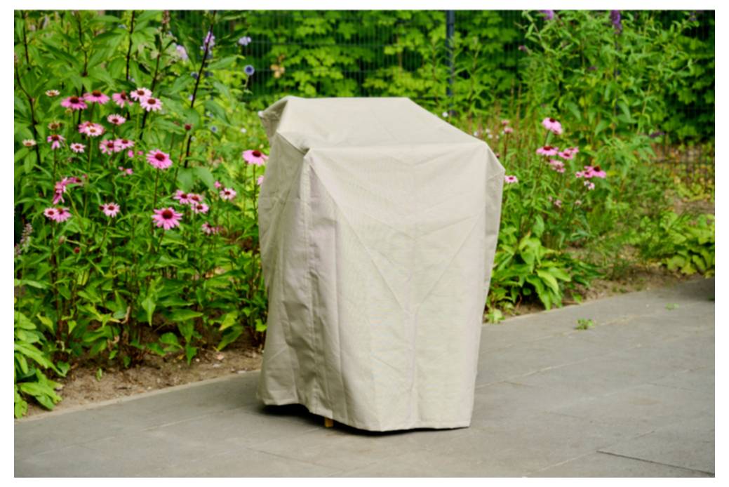 Eine beige Schutzhaube über einem Objekt im Freien auf einem gepflasterten Weg neben rosa Blüten und grünem Gartenlaub drapiert.