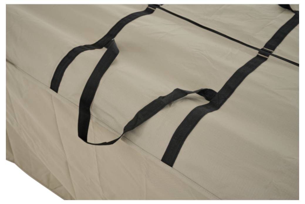 Nahaufnahme einer beigen Stofftasche oder Matratzenschutzhülle mit schwarzen Tragegriffen, die über sie gelegt sind.