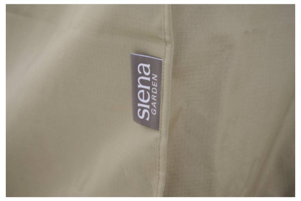Nahaufnahme einer Naht eines beigefarbenen Stoffkleidungsstücks mit einem kleinen Etikett mit der Aufschrift „Siena Garden