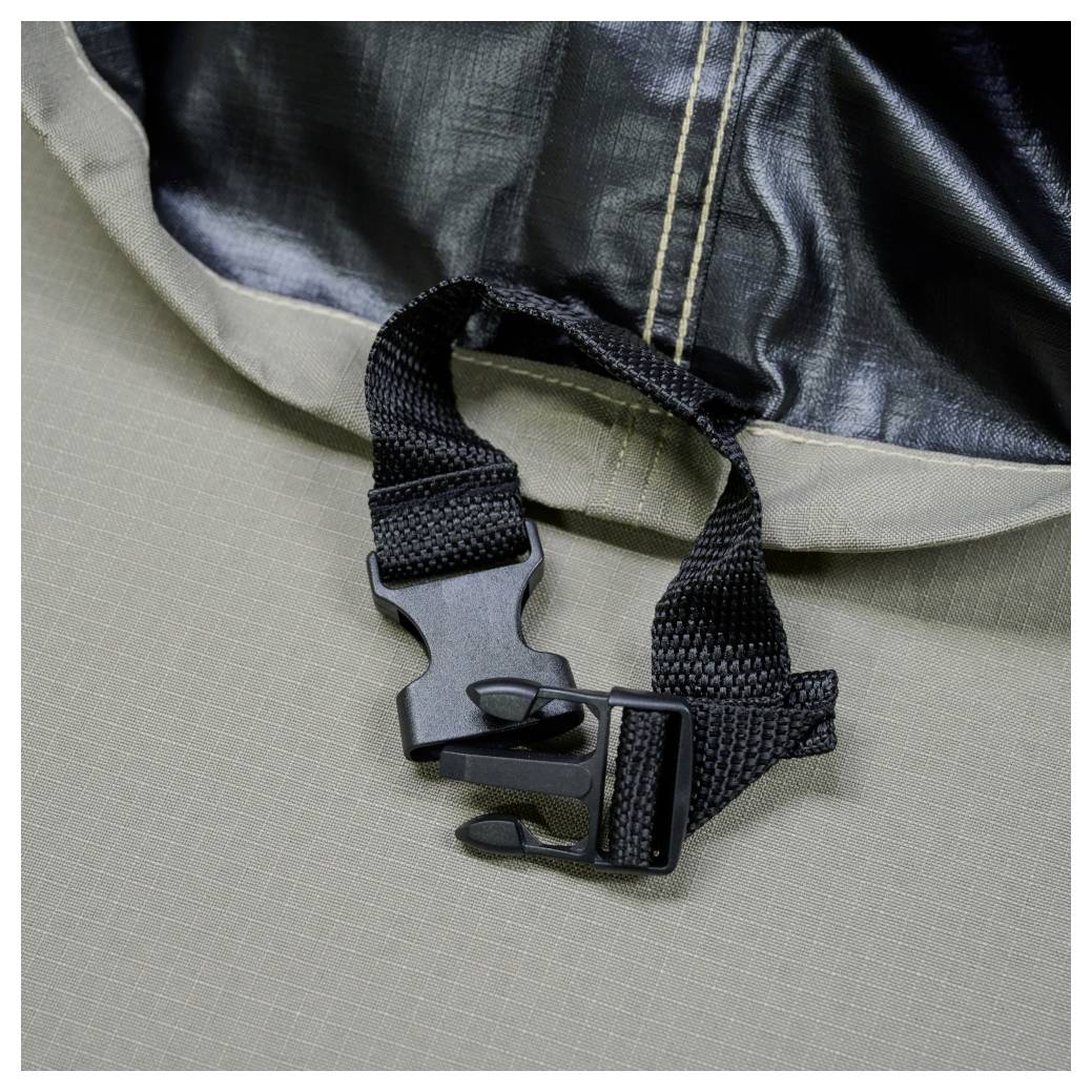 Nahaufnahme einer schwarzen Kunststoffschnalle und eines Riemens, die an einer grauen Stoff-Tasche oder Zeltplane befestigt sind.