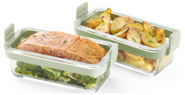 Zwei Meal-Prep-Behälter mit gebackenem Lachs, Brokkoli und gebratenen Kartoffelkeilen auf weißem Hintergrund.
