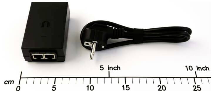 Ein schwarzer Power-over-Ethernet-Splitter mit zwei Ethernet-Anschlüssen und einem Stromkabel, auf einem Lineal zur Größendarstellung gezeigt; Kabellänge mit 5 Zoll bis 10 Zoll gekennzeichnet.