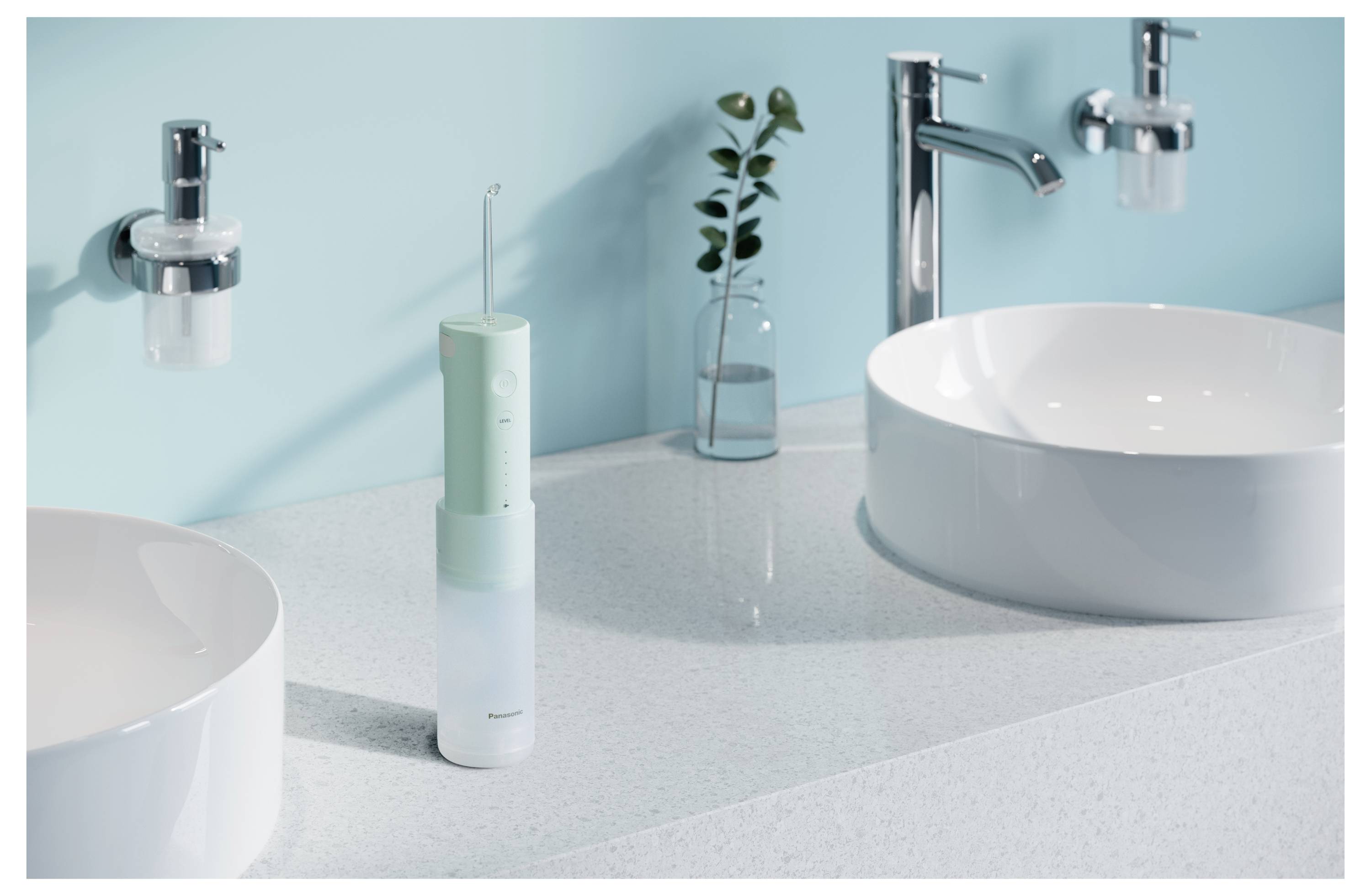 Modernes Badezimmerspiegelschränkchen mit zwei weißen Waschbecken, Chromarmaturen und einer mintgrünen elektrischen Zahnbürste oder Munddusche auf der Arbeitsplatte.