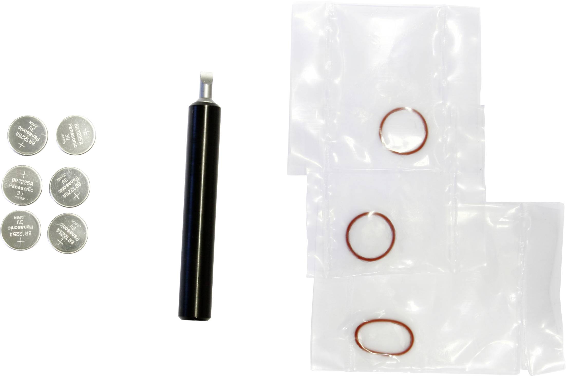 Verschiedene Kleinteile auf Weiß angeordnet: sechs silberne Knopfzellbatterien, ein schwarzes zylindrisches Werkzeug und drei durchsichtige Plastiktüten mit roten Gummi-O-Ringen.