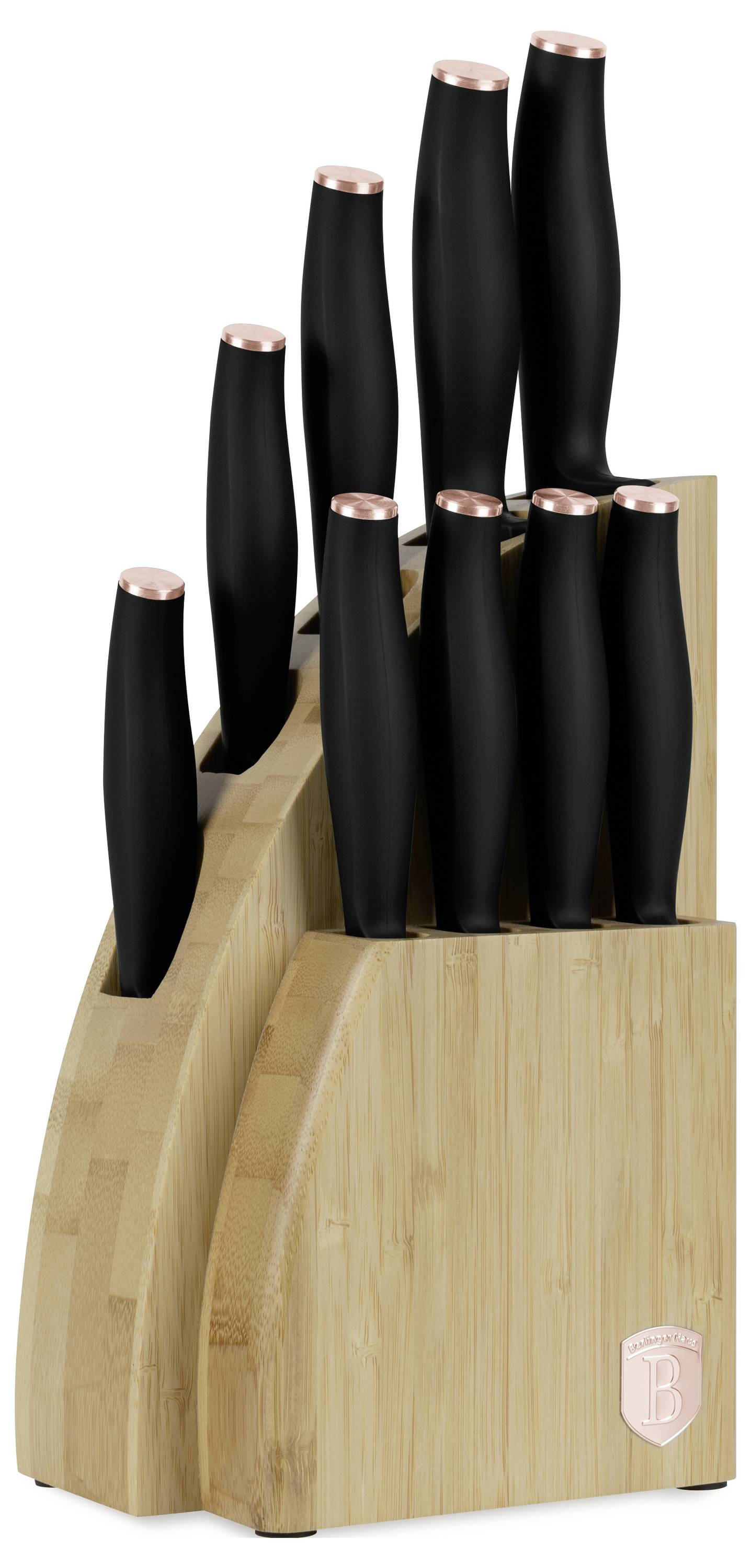 Holzblock für Messer mit mehreren schwarzgestielten Messern mit kupferfarbigen Oberteilen, vor weißem Hintergrund fotografiert.