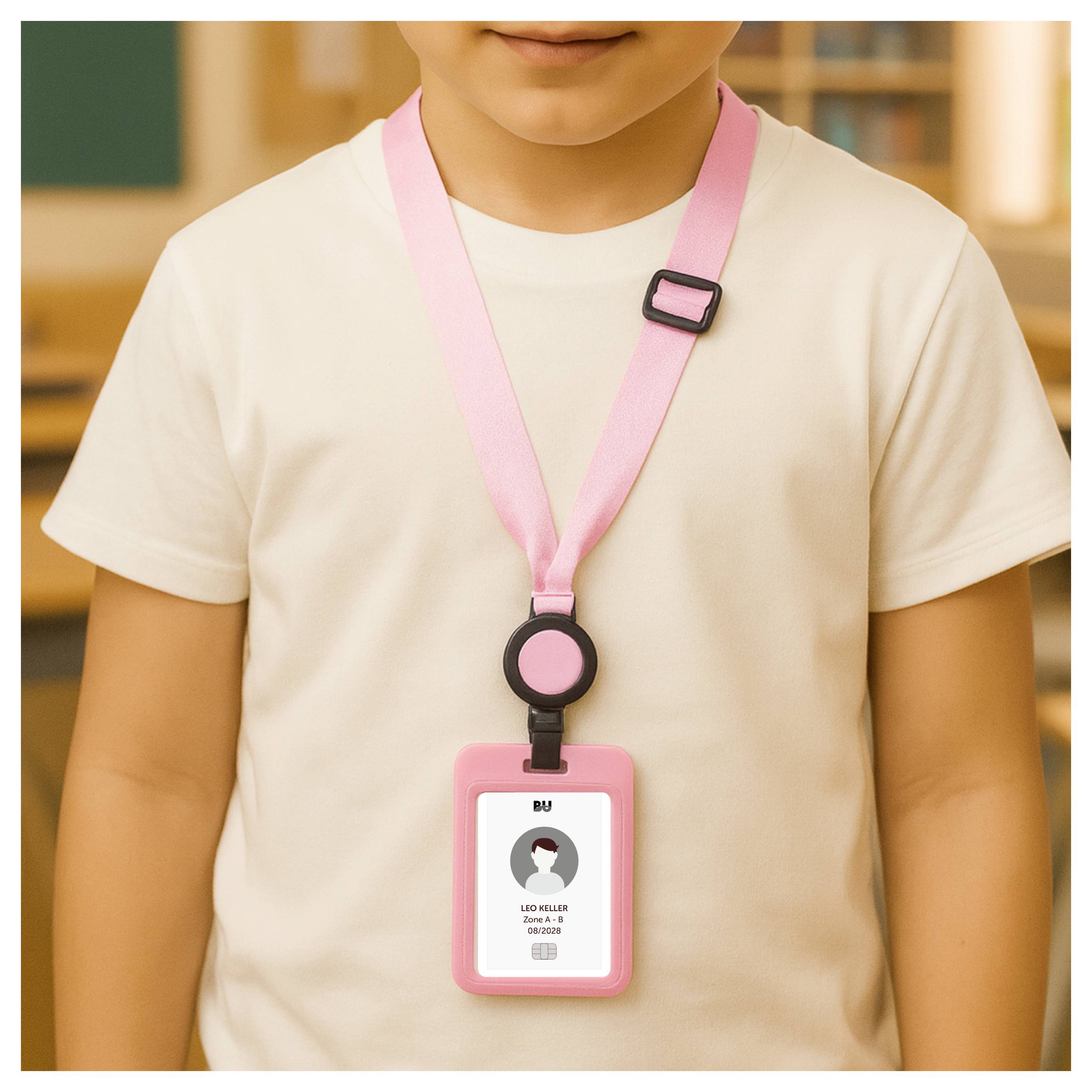Kind, das einen rosa Umhängeband und einen Ausweisanhänger über einem weißen Hemd trägt, von der Brust aufwärts in Innenräumen dargestellt.