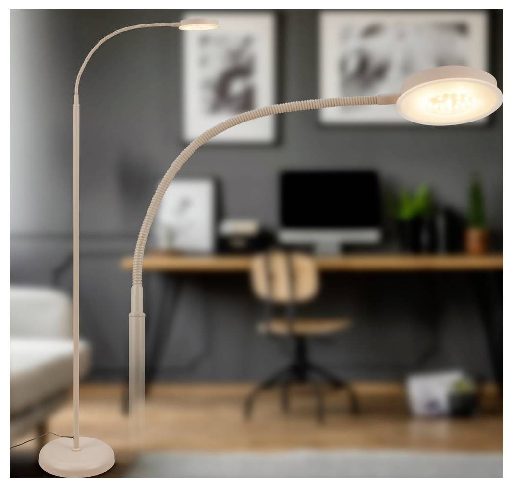 Zwei verstellbare Stehlampen beleuchten ein Heimbüro mit einem Schreibtisch, Computer, Stuhl und gerahmten Wandkunstwerken im Hintergrund.