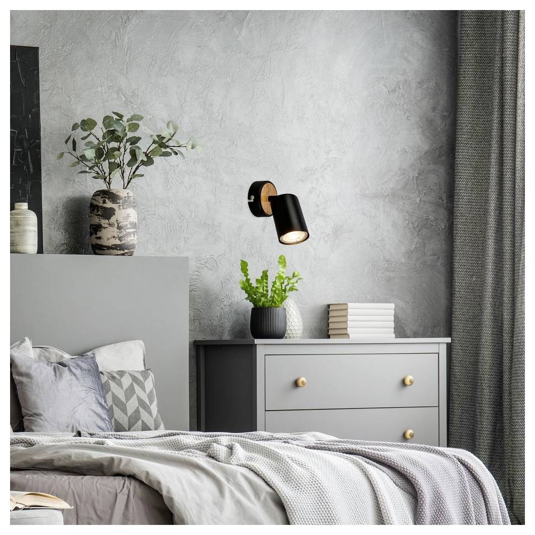 Modernes grau eingerichtetes Schlafzimmer mit Bett, Kommode, Pflanzen, Wandleuchte und Vorhängen.