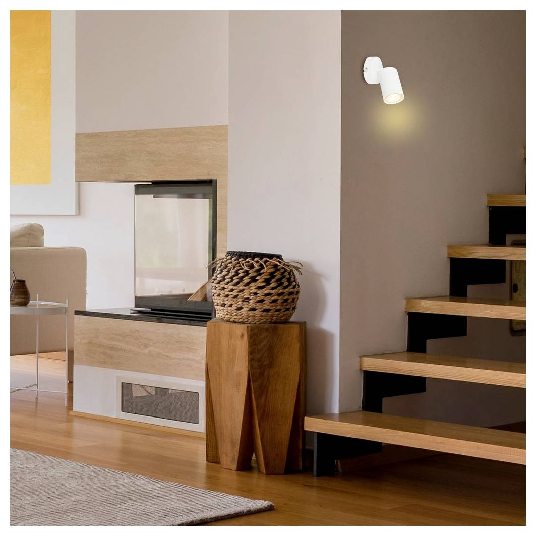 Modernes Wohnzimmer mit eingebautem Kamin und Holztreppe, mit minimalistischer Einrichtung und warmem Holzfußboden.