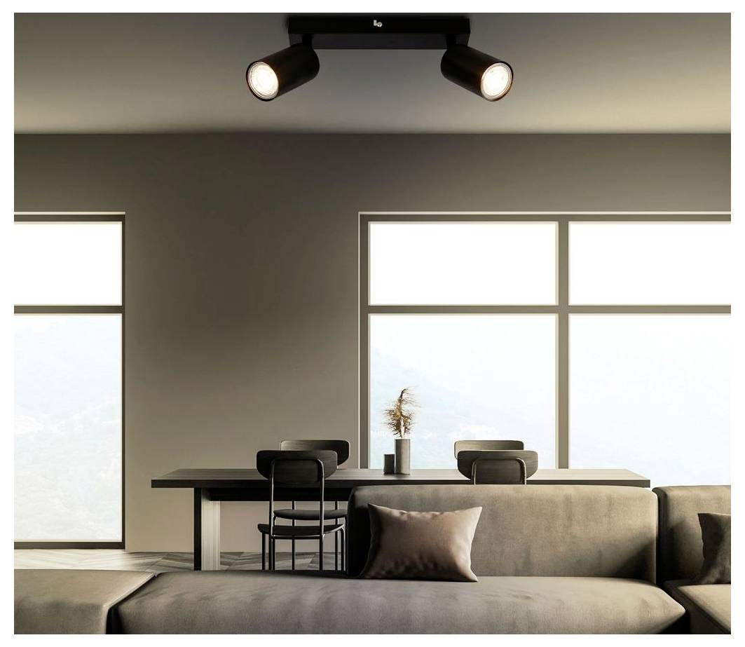 Modernes minimalistisches Wohnzimmer mit Sofa, Esstisch, Stühlen, großen Fenstern und Deckenspotlights.
