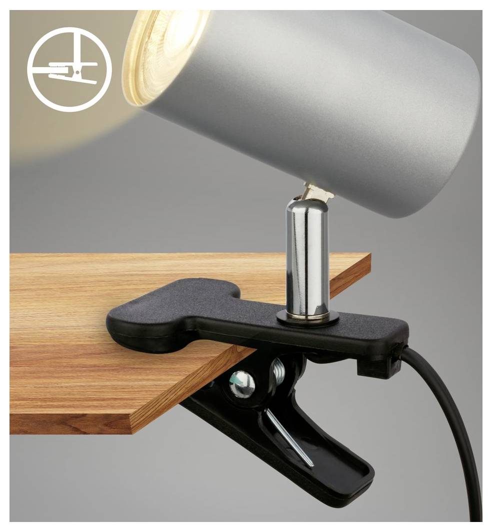 Schwarzer Klemmstrahler an einem Holzschreibtisch befestigt, mit verstellbarem silbernem Lampenkopf und Stromkabel, zeigt eine sichere Befestigungsklemme.