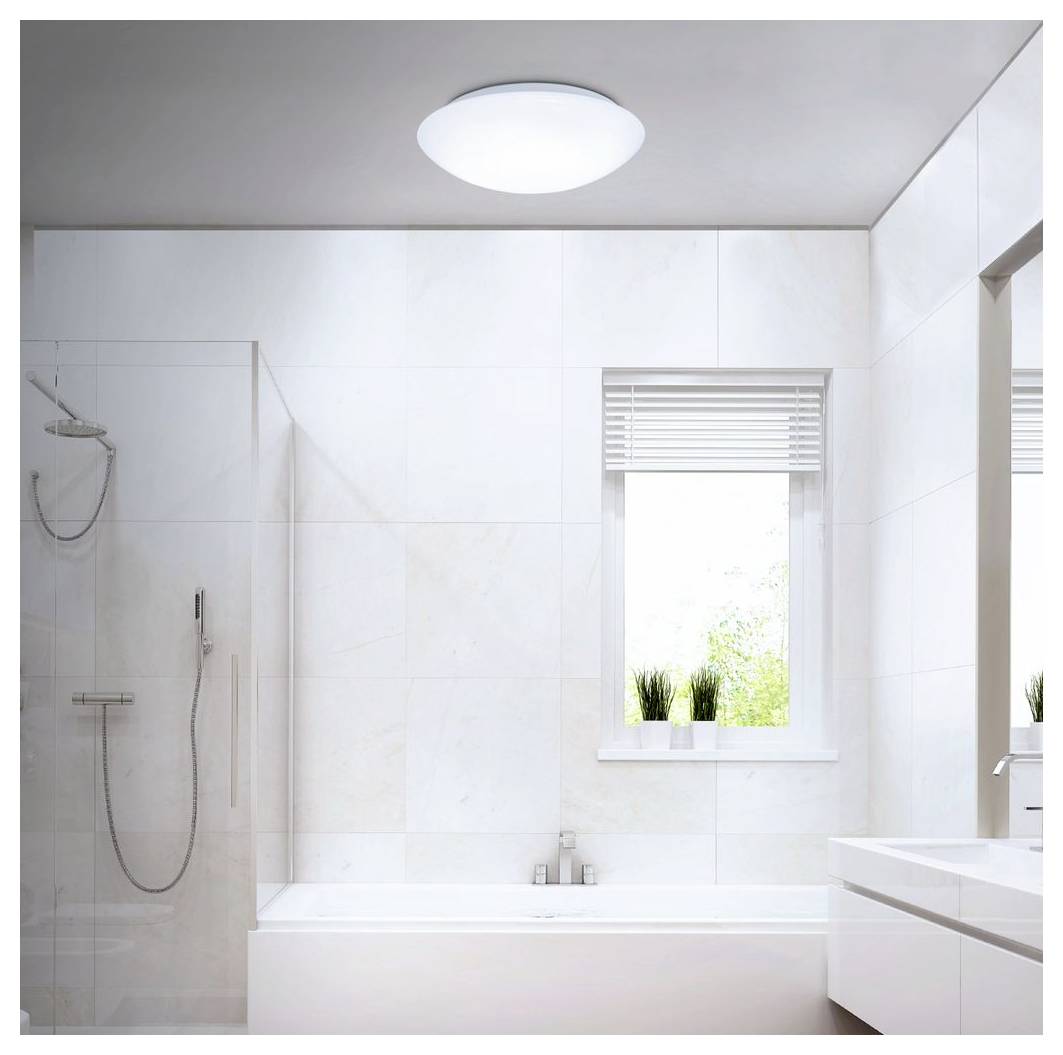 Helles modernes Badezimmer mit einer Badewanne, Glasdusche, Waschbecken und Fenster mit Jalousien sowie Topfpflanzen.