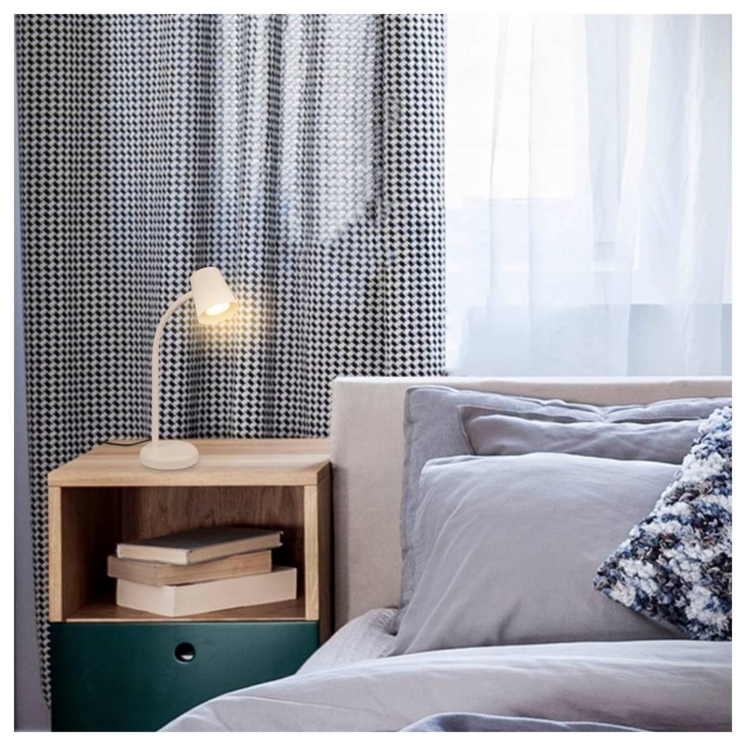 Gemütliche Schlafzimmerecke mit einem Bett, einer Nachttischlampe und einem hölzernen Nachttisch mit Büchern daneben, bemalte Vorhänge und ein helles Fenster.