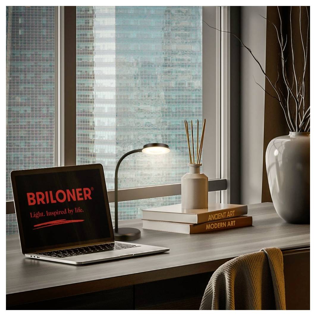 Moderner Schreibtisch am Fenster mit einem geöffneten Laptop, auf dem „BRILONER