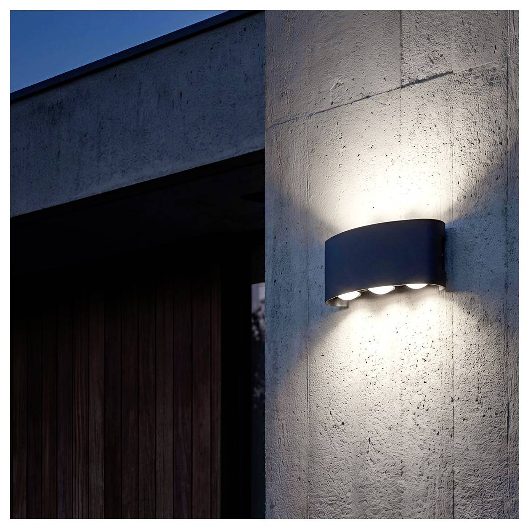 Außenwandleuchte, die an einer Betonaussenwand über einer dunklen Tür montiert ist und einen hellen Lichtkegel wirft.