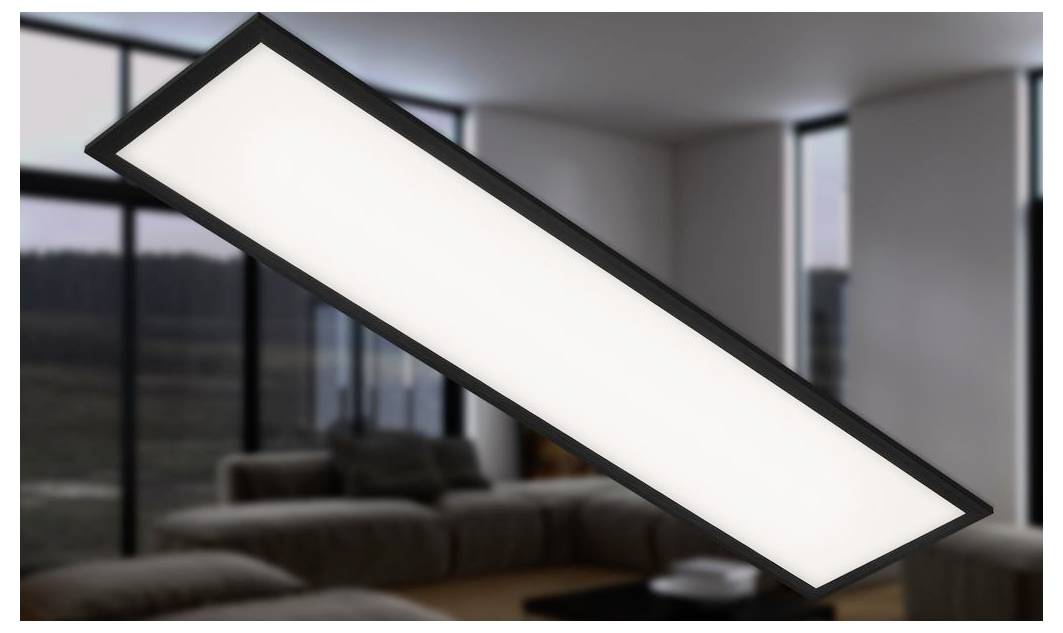 Eine lange rechteckige Deckenleuchte mit schwarzem Rahmen leuchtet weiß in einem modernen Wohnzimmer.